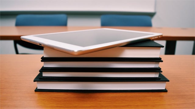 Tablet on a stack of books in a classroom