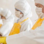 Workers at a poultry factory wearing protective clothing and masks