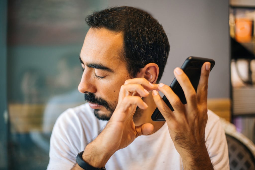 A blind man using his cell phone.